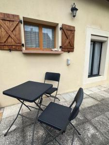 a table and two chairs next to a building at L'art de vivre conjugué au calme in Balloy
