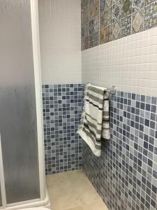 y baño con ducha de azulejos azules y toalla. en Residential Oasis 25, en Mojácar