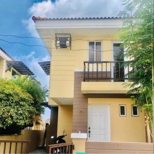 a yellow house with a balcony on the side of it at Danarose residences rental in Bacoor
