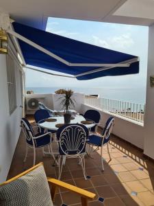 balcón con mesa, sillas y vistas al océano en Residential Oasis 25, en Mojácar