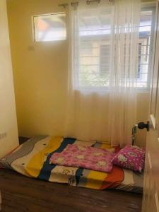 uma cama num quarto com uma janela em Danarose residences rental em Bacoor