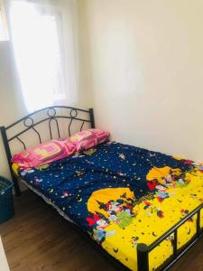 a bedroom with a bed with a mickey mouse comforter at Danarose residences rental in Bacoor