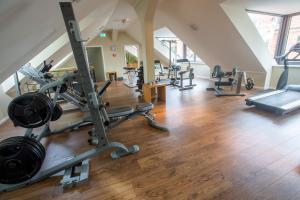 a gym with several treadmills and machines in a attic at Hotel Hafenresidenz Stralsund in Stralsund