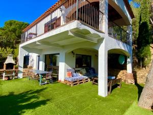 a house with a patio with a table and a balcony at Villa Buda Begur in Begur