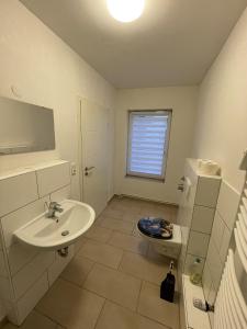 a white bathroom with a sink and a toilet at Zweckmäßige Monteurwohnung nahe Innenstadt in Neumünster