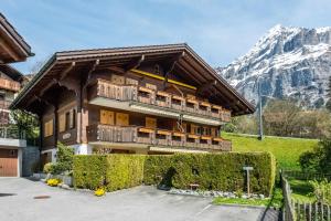 a building with a balcony with a mountain in the background at Apartment Dolce Vita - GRIWA RENT AG in Grindelwald