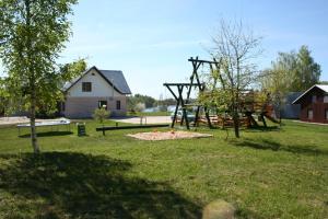 a playground in a park with a tree at Radi in Brocēni