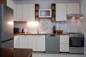 una cocina con armarios blancos y fregadero en Holiday Home Ines, en Vrsi