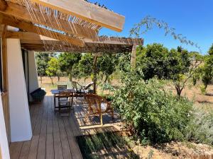 a wooden deck with a table and chairs on it at SeaHouseNature in Porto Covo
