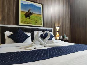 uma cama de hotel com uma toalha em forma de coração em The Corbett Jungle By JitaInn em Rāmnagar
