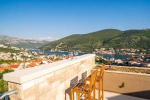 2 sillas sentadas en un balcón con vistas a la ciudad en Apartments Villa Arcadia, en Dubrovnik