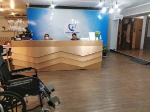 dos mujeres sentadas en una recepción en una oficina en WellQuest Wellness Ladprao Soi 1 en Bangkok