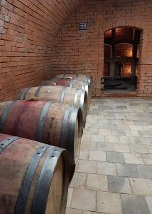 - une rangée de tonneaux de vin dans une salle en briques dans l'établissement Sklep Víno Strýček, à Velké Bílovice