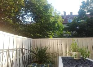 a privacy fence with a table and potted plants at Sofia Palms: Modern apartment with a large terrace in Sofia