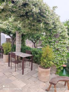 einen Tisch und Stühle auf einer Terrasse mit Bäumen in der Unterkunft Corte Piri in Tricase