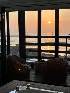 uma vista para o oceano a partir de uma varanda com 2 cadeiras em Farms Village em Jeju