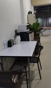 a white table with a chair in a room at Chiang Mai Happy House Hostel in Chiang Mai
