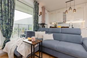 a living room with a blue couch and a table at Warsaw Kotsisa Apartments with Parking by Renters in Warsaw