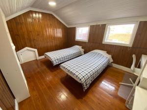 Duas camas num pequeno quarto com painéis de madeira em BREINER 28 no Porto