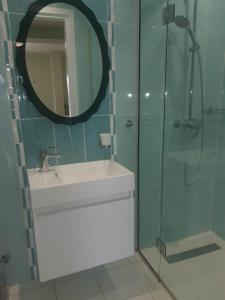 a bathroom with a sink and a shower with a mirror at LULA VILLA in Ayia Napa