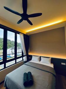 - une chambre avec un lit et un ventilateur de plafond dans l'établissement LAVIE HOTEL & APARTMENT, à Brinchang