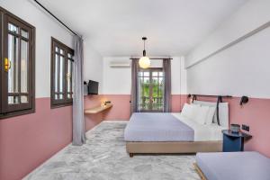 a bedroom with pink and white walls and a bed at Estival Concept in Paliouri