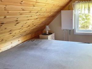 1 dormitorio con cama y techo de madera en Holiday home HALDEN II, en Halden