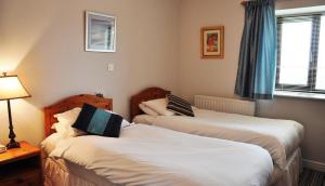 GowertonにあるThe Gower Golf Clubのベッドが2つと窓があるホテルの部屋