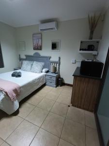 a bedroom with a bed and a flat screen tv at Bello Guest in Bloemfontein