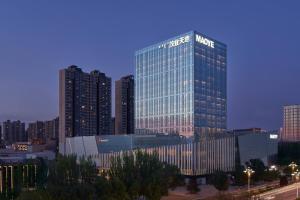 a tall building with a sign on it in a city at Baotou Marriott Hotel in Baotou