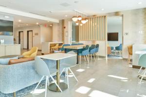 eine Lobby mit Tischen und Stühlen in einem Gebäude in der Unterkunft TownePlace Suites by Marriott Hixson in Hixson