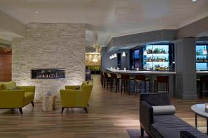 een lobby met een bar en een open haard bij Milwaukee Marriott West in Waukesha