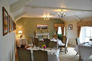 GowertonにあるThe Gower Golf Clubのダイニングルーム(テーブル、椅子、暖炉付)