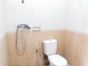y baño con aseo y ducha. en Loven Sanur Guest House, en Sanur