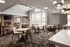 une salle à manger avec des tables, des chaises et une cheminée dans l'établissement Residence Inn Mount Olive At International Trade Center, à Stanhope