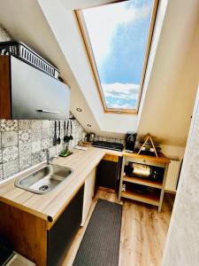 eine Küche mit einem Waschbecken und einem großen Dachfenster in der Unterkunft Apartmány v ráji (Českém) in Blata