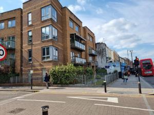 un edificio de ladrillo en una calle de la ciudad con un autobús en Tottenham Spur Hideaway en Londres