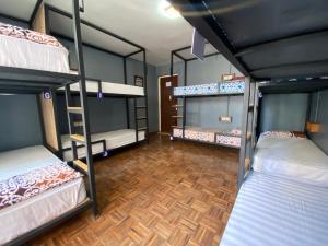 a room with four bunk beds and a wooden floor at Alobar1000 Hostel in Kathmandu