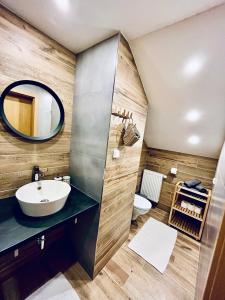 ein Bad mit einem Waschbecken und einem Spiegel in der Unterkunft Apartmány v ráji (Českém) in Blata