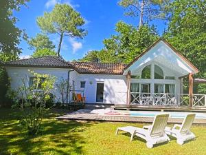 a house with a pool and two chairs in the yard at Louise-Angèle in Biscarrosse