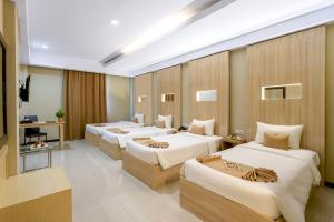 ein Hotelzimmer mit 4 Betten in einem Zimmer in der Unterkunft Sahid Azizah Syariah Hotel and Convention Kendari in Lepoleop