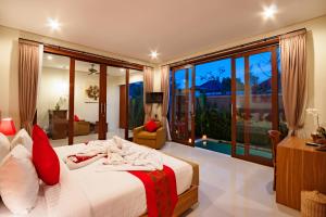 sypialnia z łóżkiem i dużym oknem w obiekcie Aishwarya Villa, Bali w mieście Ketewel