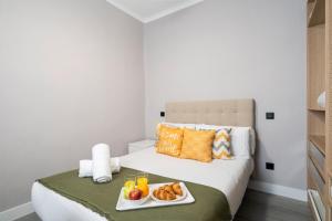 a hotel room with a bed with a tray of food on it at dobohomes - Juan de Olias in Madrid