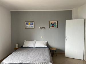 a bedroom with a bed and two pictures on the wall at Apartments Cvjetković in Mlini