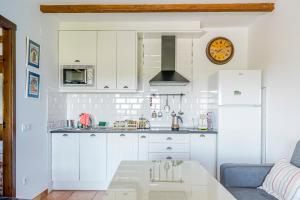 a kitchen with white cabinets and a table at La Jara · Apartamentos Rurales in Serrejón