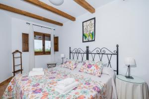 Un dormitorio blanco con una cama con toallas. en La Jara · Apartamentos Rurales, en Serrejón