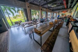 a cafeteria with wooden benches and people sitting at tables at Mad Monkey Hoi An in Hoi An