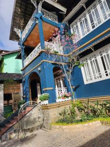 ein blaues Haus mit einer Veranda und einer Bank davor in der Unterkunft In Real Life in Khu Chi Lăng