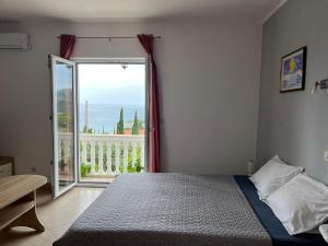 a bedroom with a bed and a large window at Apartments Cvjetković in Mlini