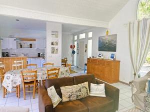 a living room with a couch and a dining room at Louise-Angèle in Biscarrosse